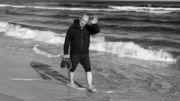  - na zdjęciu trener Marek Maciejewski spacerujący po plaży. Zdjęcie czarno-białe