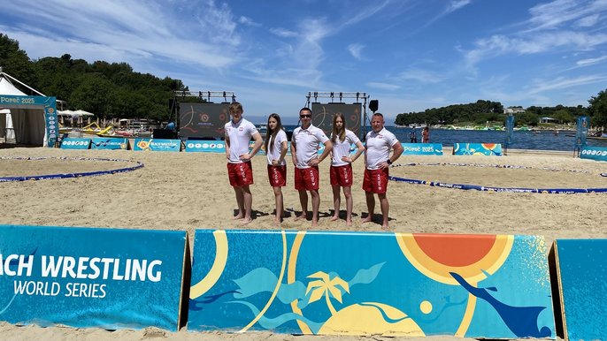  - na zdjęciu zawodnicy Master Łódź na arenie do beach wrestlingu wraz z trenerami ubrani w narodowe barwy